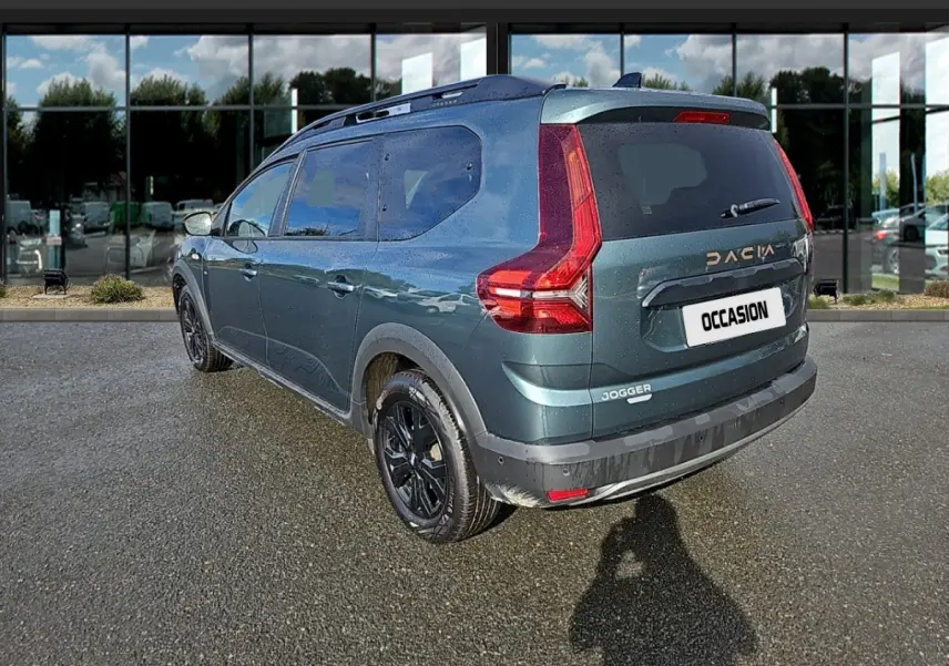 Vue 3/4 arrière droite d'un Dacia Jogger vert 2024 avec jantes noires et feux arrière en forme de L.