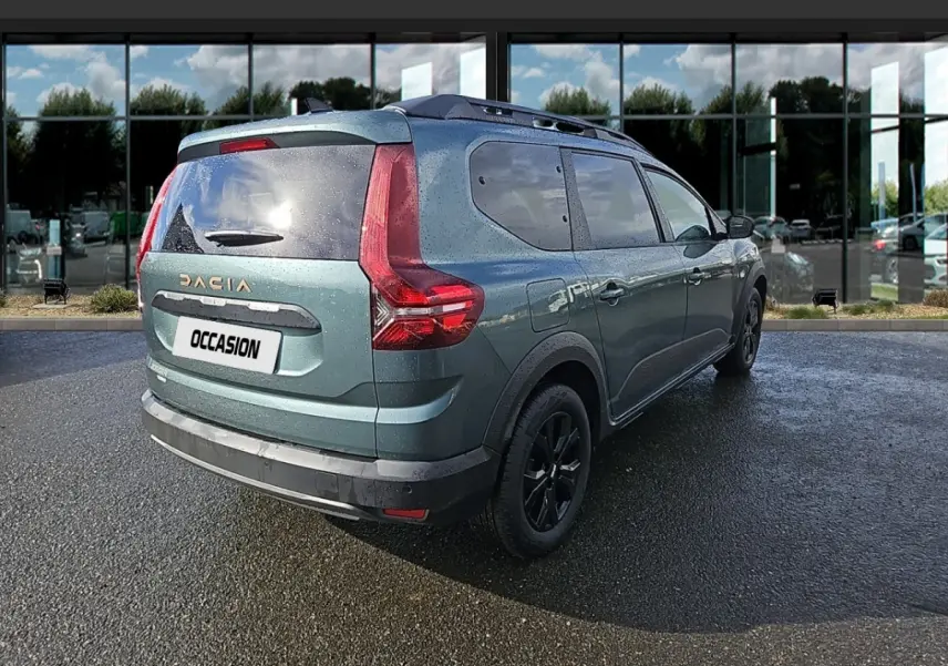 Vue 3/4 arrière droite du Dacia Jogger vert avec feux arrière en forme de L et barres de toit noires.