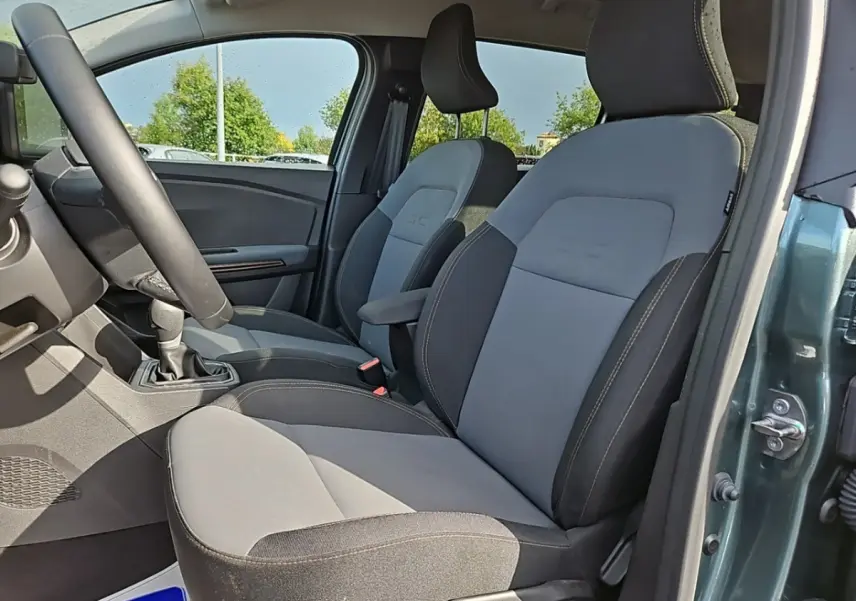 Vue intérieure côté gauche montrant les sièges avant gris et noirs du Dacia Jogger Extreme Hybrid 2024 vert.
