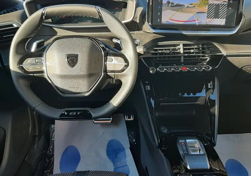 Intérieur de la Peugeot 2008 GT 2025, vue frontale du volant compact et écran tactile affichant la caméra de recul.