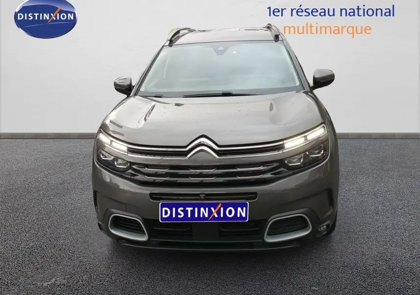 Vue frontale du Citroën C5 Aircross hybride rechargeable 2022 en gris platinium avec feux LED allumés.