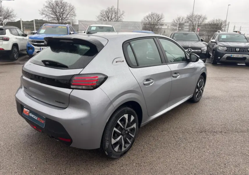 Vue 3/4 arrière droite d'une Peugeot 208 Hybrid gris clair avec jantes 16 pouces et feux arrière LED distinctifs.