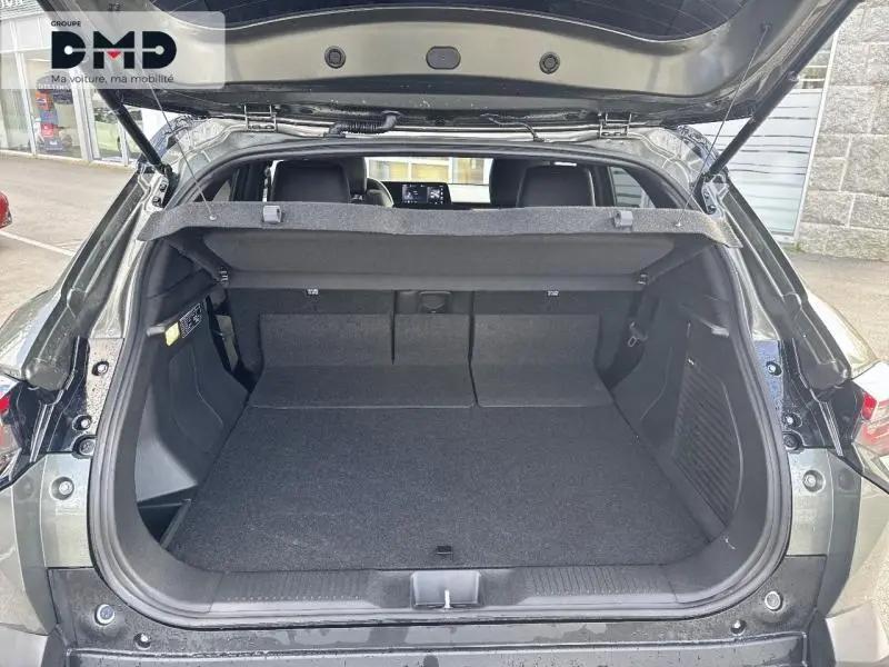 Vue arrière du coffre ouvert du Suzuki Vitara 2026 vert Land Breeze avec toit noir, montrant un espace de chargement spacieux et propre.