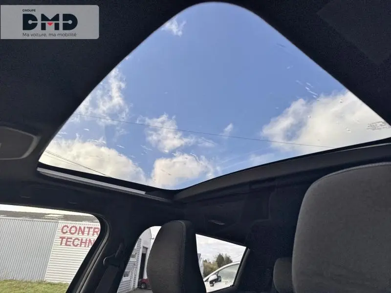 Toit panoramique en verre du Suzuki Vitara 2026 Style, vue intérieure depuis l'arrière avec ciel visible.