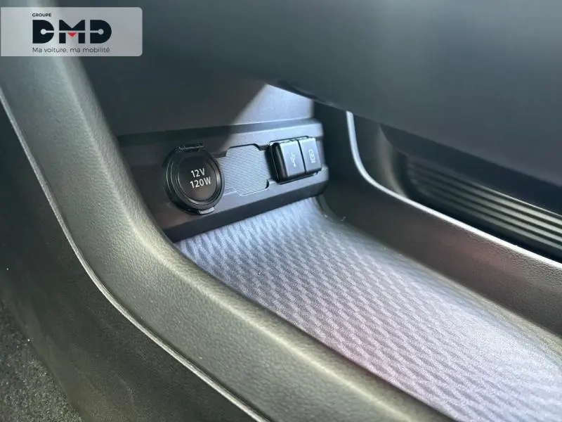 Gros plan sur la prise 12V et ports USB dans l'espace de rangement côté passager du Suzuki Vitara 2026.