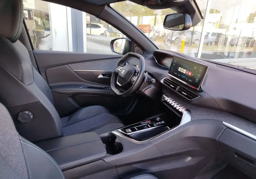 Vue intérieure côté conducteur du Peugeot 3008 gris Platinium 2023, avec tableau de bord numérique et écran tactile central.