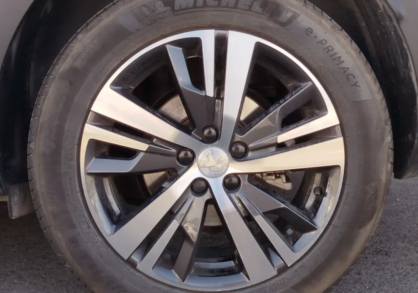 Gros plan sur la jante alliage bicolore noire et argentée du Peugeot 3008 Gris Platinium, pneu Michelin visible.