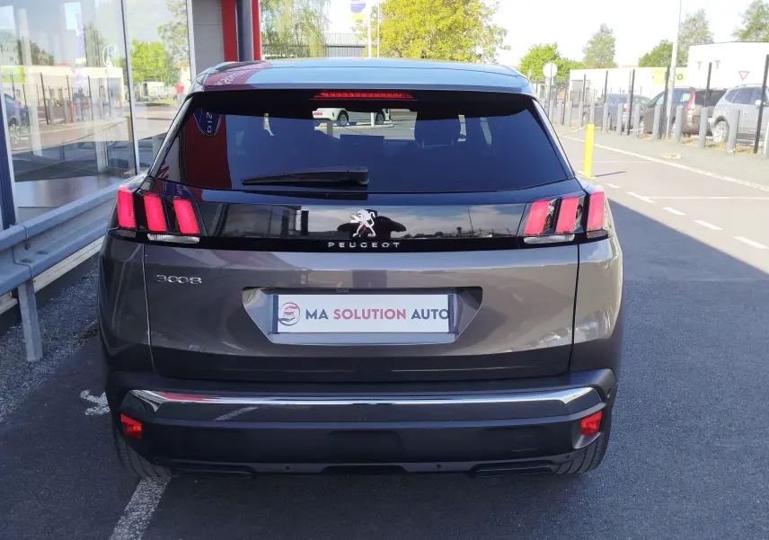 Vue arrière d'un Peugeot 3008 gris Platinium 2023 avec feux arrière à trois griffes et lunette arrière teintée.