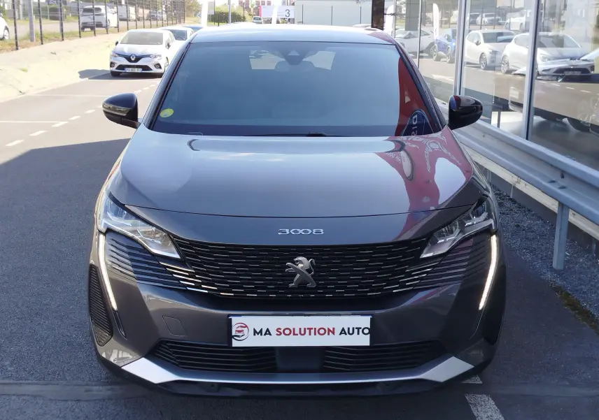 Vue avant d’un Peugeot 3008 gris Platinium 2023 avec calandre noire et feux LED verticaux allumés.