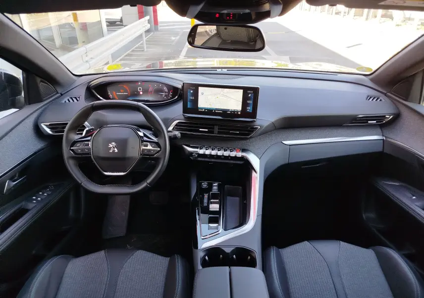 Vue intérieure avant du Peugeot 3008 gris Platinium 2023, avec tableau de bord numérique et écran tactile central.