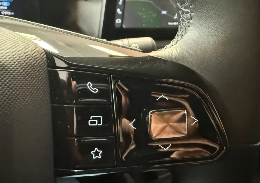 Gros plan sur les commandes tactiles noires du volant en cuir microfibre de la MG3 Luxury, avec icônes blanches rétroéclairées.