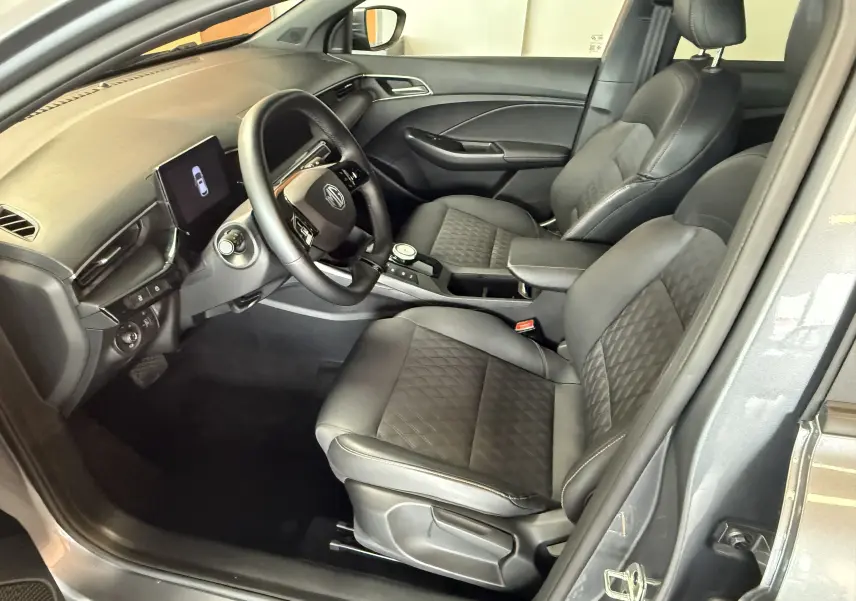 Vue intérieure côté conducteur du MG3 1.5 L Hybrid+ Luxury en gris Hampstead, avec sièges noirs en similicuir et volant cuir.