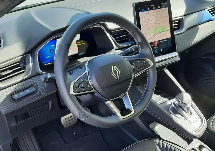 Vue intérieure côté conducteur du Renault Symbioz E-Tech Full Hybrid 145 Esprit Alpine 2025, volant cuir noir avec écran tactile vertical central.