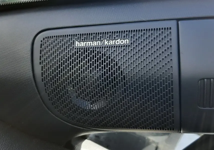Gros plan sur le haut-parleur Harman/Kardon intégré dans l'habitacle du Renault Symbioz gris Rafale.