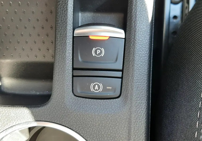 Gros plan sur les commandes de frein à main électrique et d’assistance au démarrage du Renault Symbioz E-Tech gris Rafale.