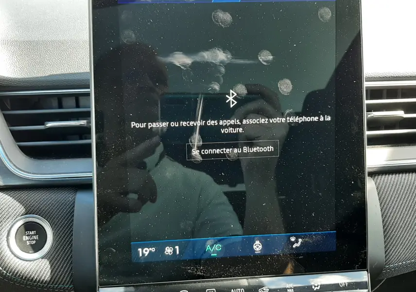 Écran tactile central du tableau de bord du Renault Symbioz gris Rafale, affichant la connexion Bluetooth avec traces de doigts visibles.