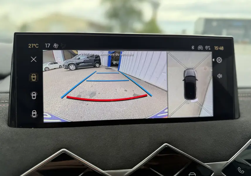 Écran de caméra de recul du DS3 hybride 2025 montrant l’arrière du véhicule avec lignes de guidage colorées.