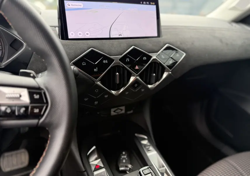 Vue intérieure du tableau de bord du DS3 Hybride 2025, avec commandes tactiles diamantées et écran tactile de navigation.