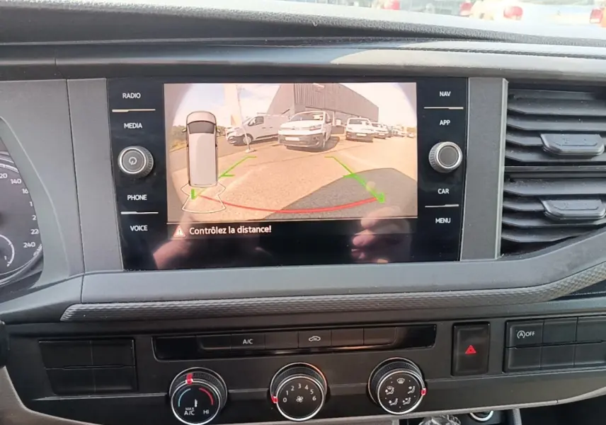 Vue intérieure du tableau de bord du Volkswagen Transporter gris foncé, avec écran tactile affichant la caméra de recul.