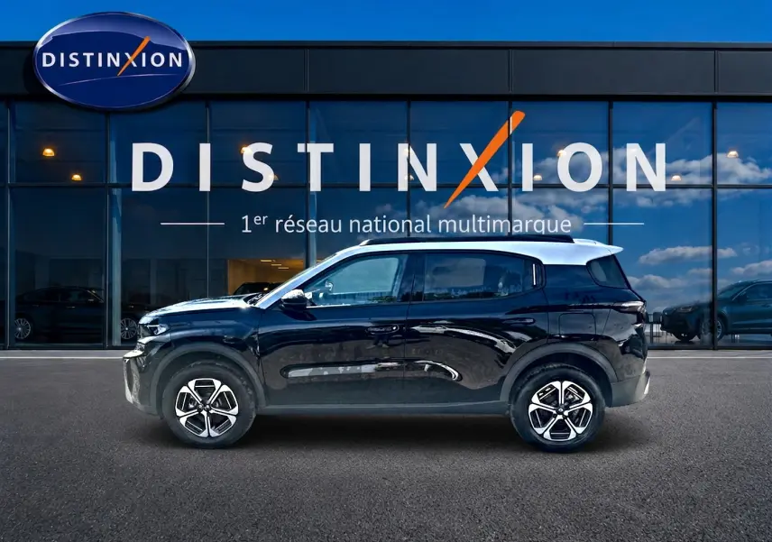 Profil côté gauche d'un Citroën C3 Aircross noir 2026 avec jantes alu devant une vitrine Distinxion.