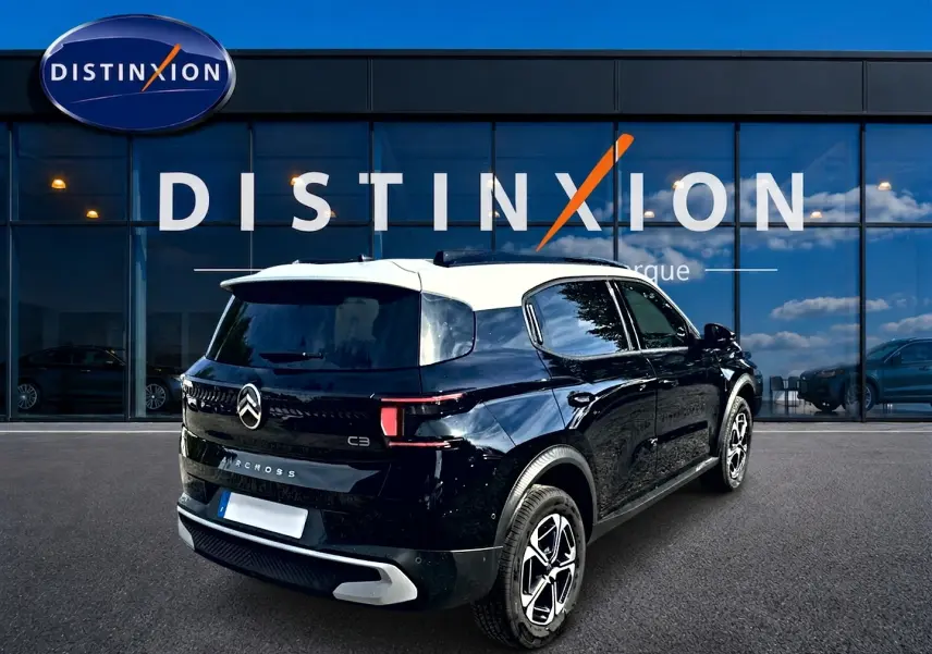 Vue 3/4 arrière droite d'un Citroën C3 Aircross noir avec toit blanc, jantes alu et feux arrière LED visibles.