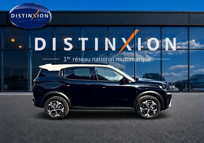 Vue latérale droite d'un Citroën C3 Aircross noir avec toit blanc, jantes alu et barres de toit visibles.