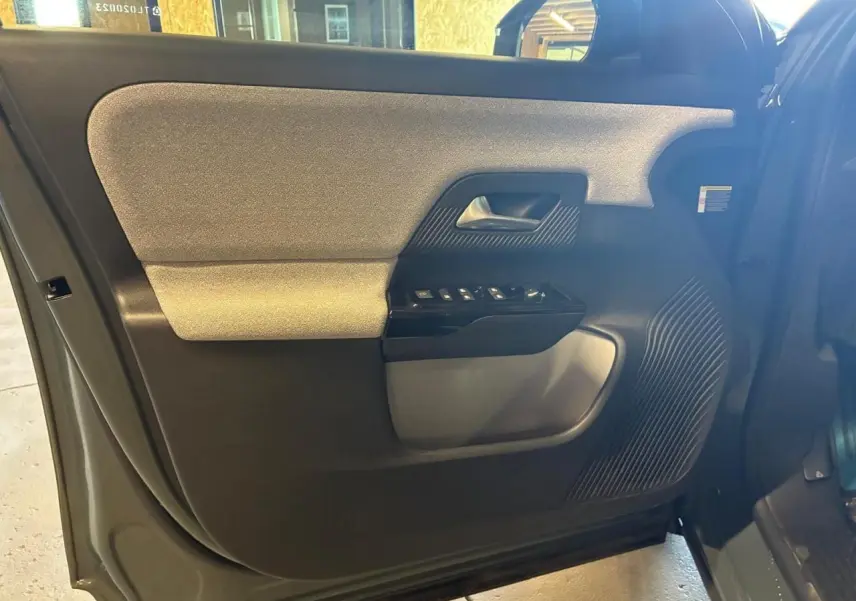 Intérieur de la porte avant gauche du Citroën C5 Aircross 2026 vert, avec commandes de vitres et poignée intégrée.