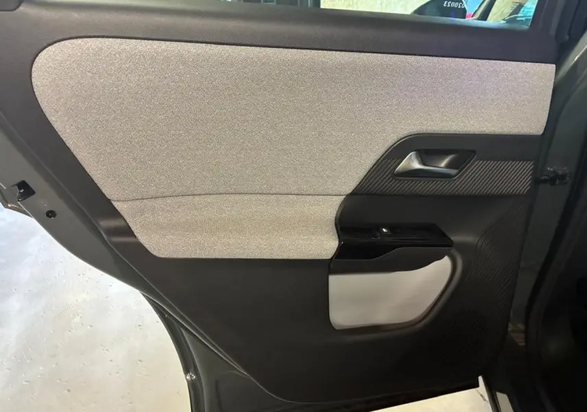 Détail de la porte arrière gauche du Citroën C5 Aircross vert 2026, avec garniture grise et noire et poignée intégrée.