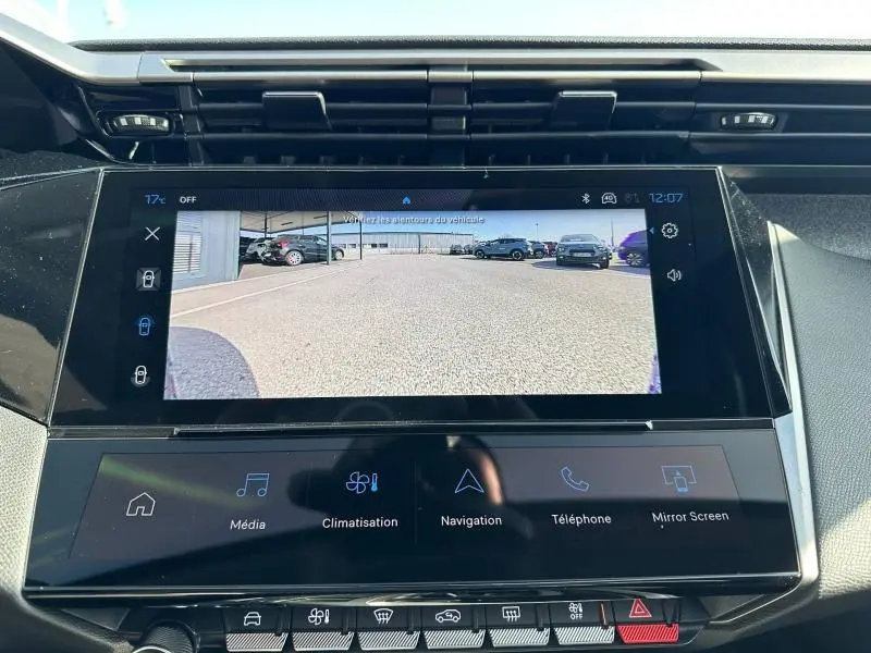 Écran tactile central affichant la caméra de recul dans l’habitacle d’une Peugeot 308 bleu, vue de face.