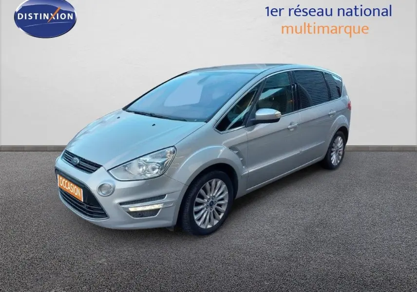 Ford S-Max gris clair métal vu en 3/4 avant droit, avec jantes alliage et feux LED allumés.