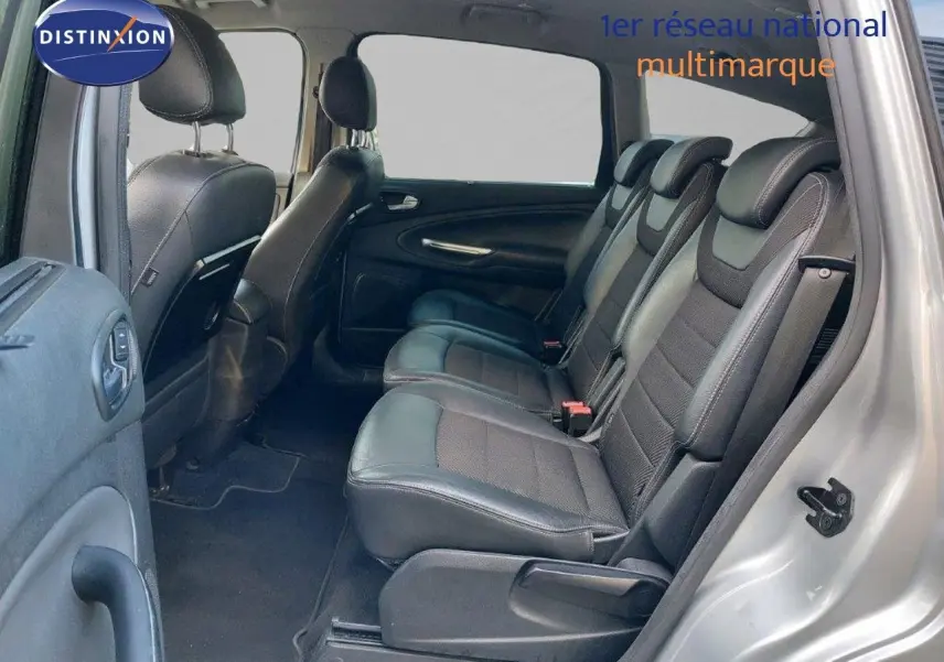 Vue latérale droite de l'intérieur du Ford S-MAX gris clair métal, montrant les sièges en cuir noir et la banquette arrière.