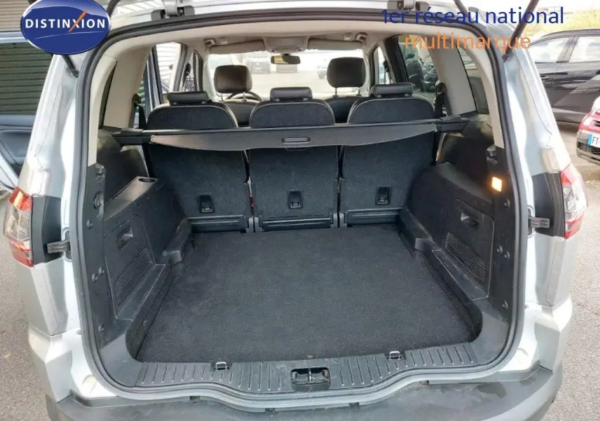 Coffre ouvert d'un Ford S-MAX gris clair métal de 2012, montrant l'espace de chargement et la banquette arrière.