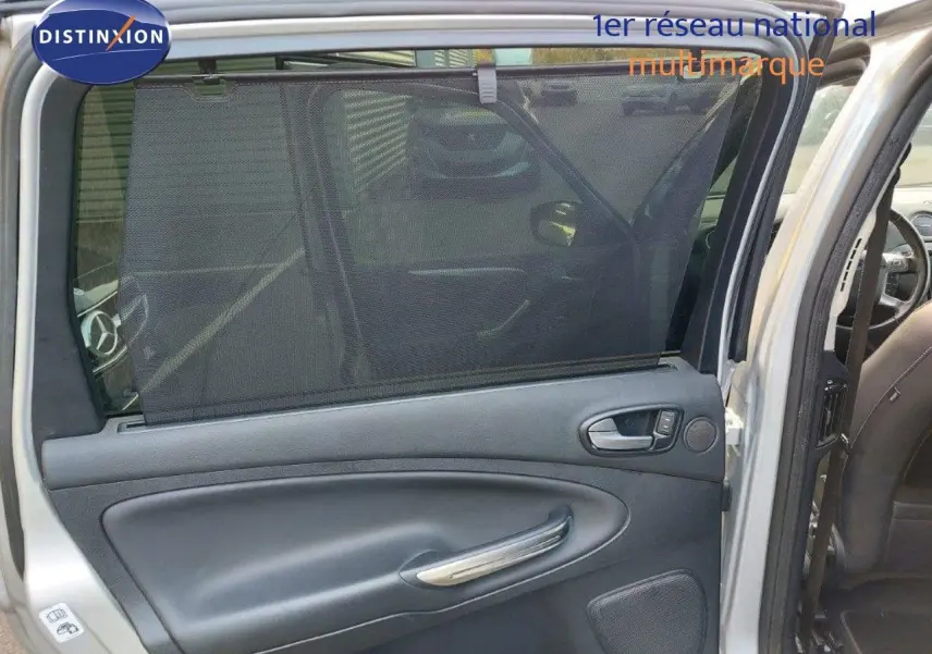 Porte arrière droite ouverte du Ford S-MAX gris clair métal, montrant la garniture intérieure noire avec pare-soleil intégré.