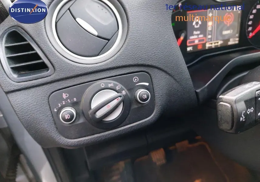 Gros plan sur la commande des phares et l'aération côté gauche du tableau de bord d'un Ford S-MAX gris clair 2012.