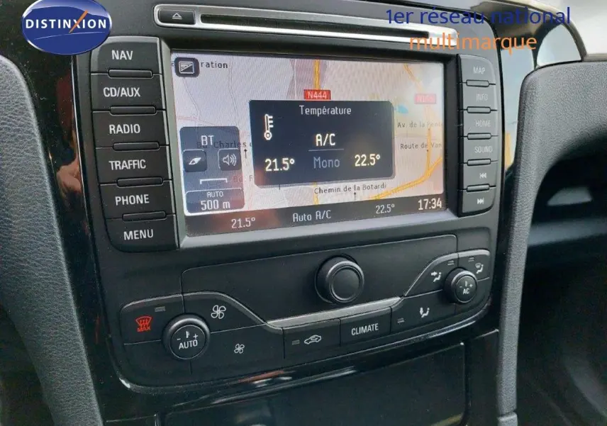 Gros plan sur la console centrale du Ford S-MAX gris clair, affichant la navigation GPS et la climatisation automatique.
