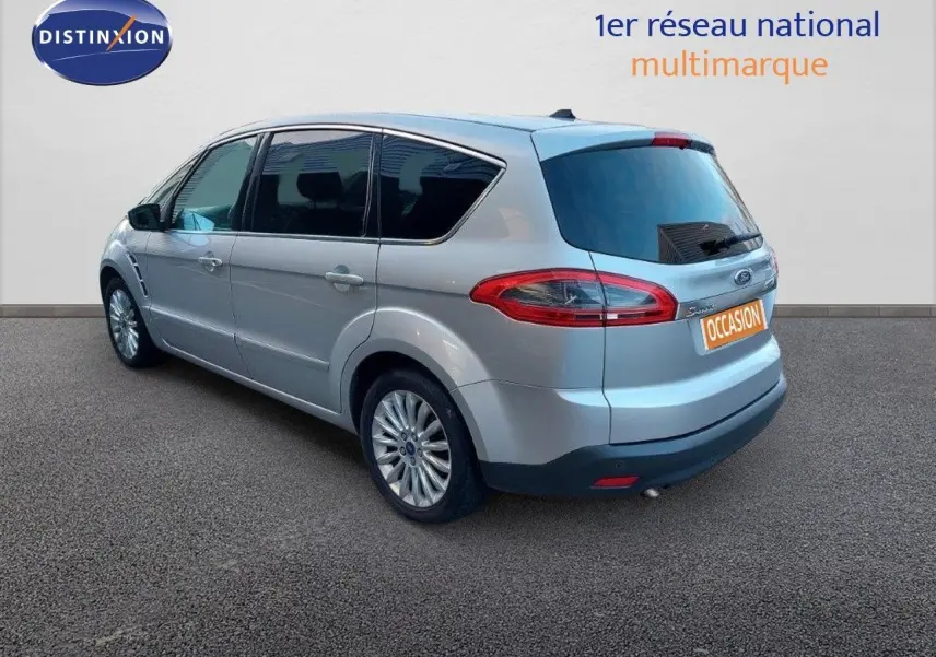 Ford S-MAX gris clair métal vu en 3/4 arrière côté gauche, avec feux arrière allongés et jantes alliage.