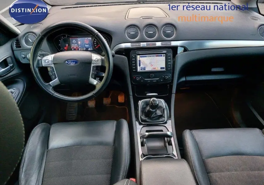 Vue intérieure de la Ford S-MAX 2012 montrant le tableau de bord noir avec GPS et levier de vitesses manuel.