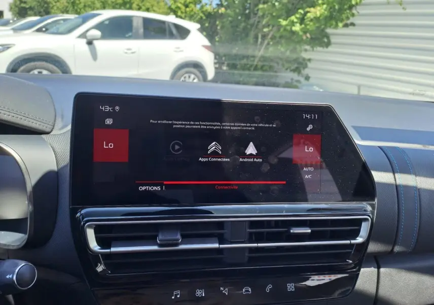 Écran tactile central du tableau de bord du Citroën C5 Aircross gris, affichant les options connectées et la climatisation.