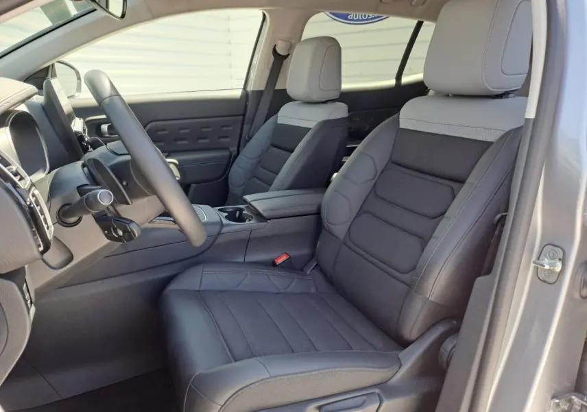 Vue intérieure côté conducteur du Citroën C5 Aircross 2024, sièges noirs avec appuie-tête gris clair et tableau de bord moderne.