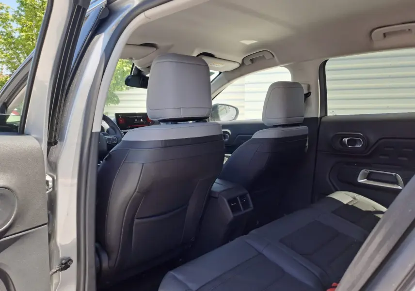 Vue intérieure arrière du Citroën C5 Aircross gris Artense, sièges bi-ton noir et gris avec détails modernes.