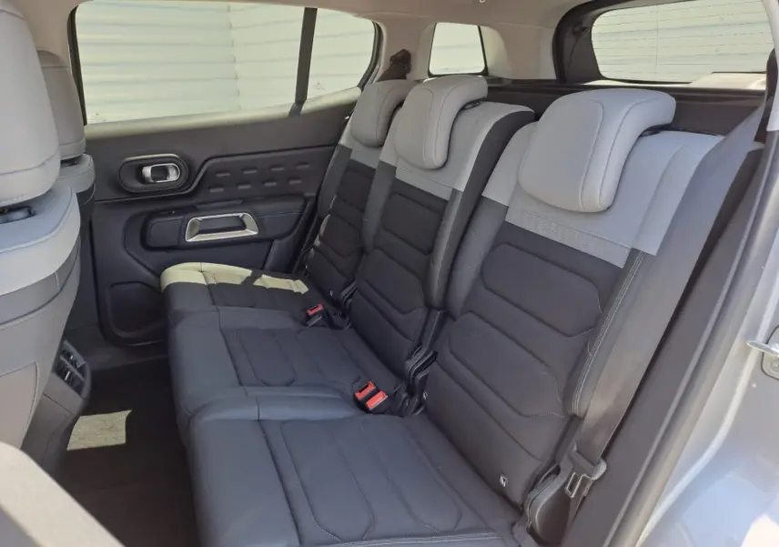 Vue latérale droite de l'intérieur arrière du Citroën C5 Aircross 2024, sièges bi-ton gris clair et noir.