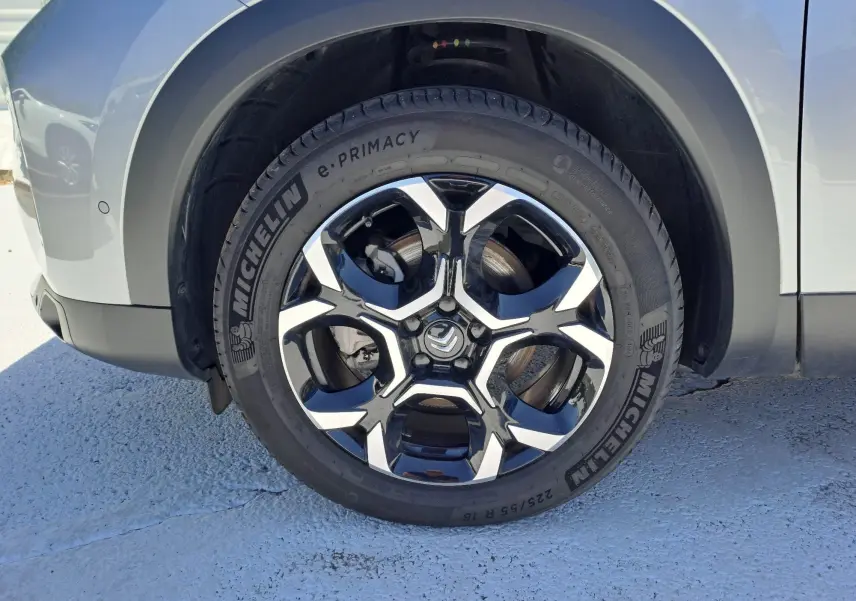 Gros plan sur la roue avant gauche du Citroën C5 Aircross gris Artense avec jante alliage biton et pneu Michelin e-Primacy.