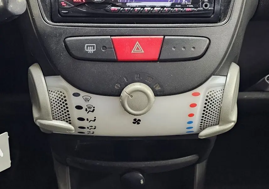 Vue rapprochée du tableau de bord de la Peugeot 107 2013 avec radio Sony et levier de vitesse manuel.