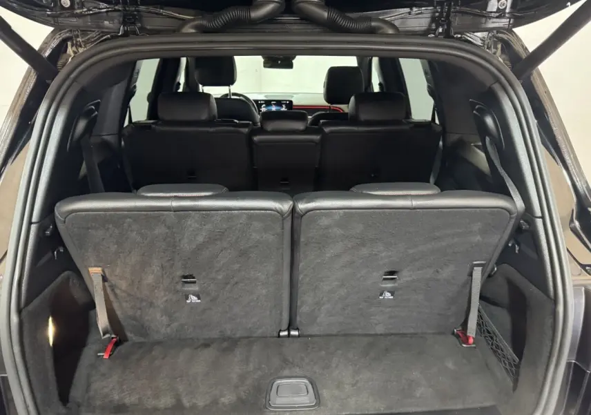 Vue arrière ouverte du coffre du Mercedes GLB 200 d AMG Line noir, montrant la 3ème rangée de sièges individuels rabattus.