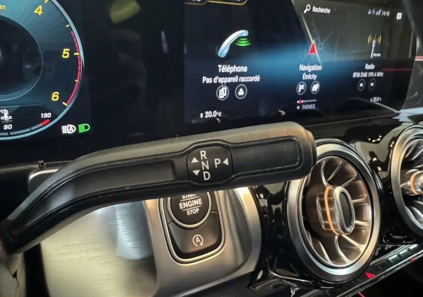 Gros plan sur la commande de boîte automatique et le tableau de bord numérique du Mercedes GLB 200 d AMG Line noir.