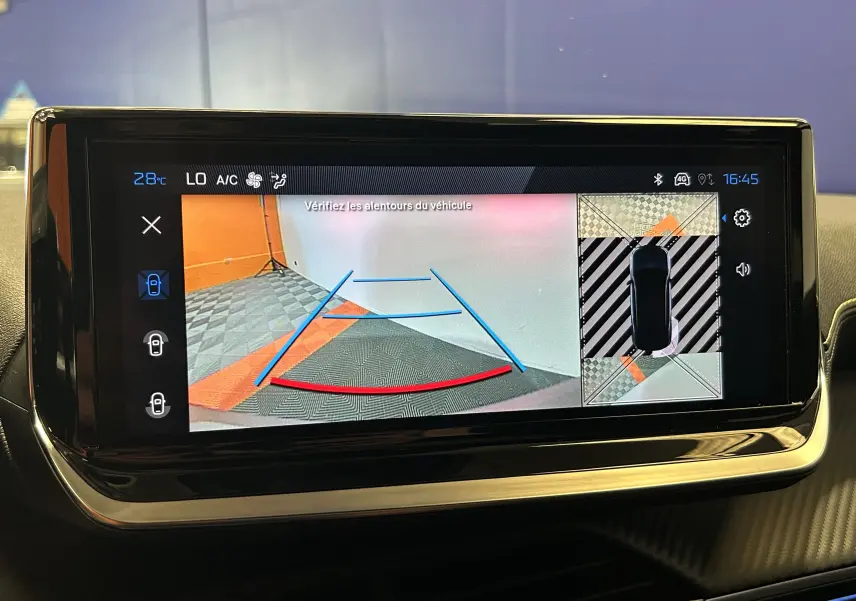 Écran intérieur de la Peugeot 2008 Hybrid 136 GT montrant la caméra de recul avec vue 360° en mode stationnement.