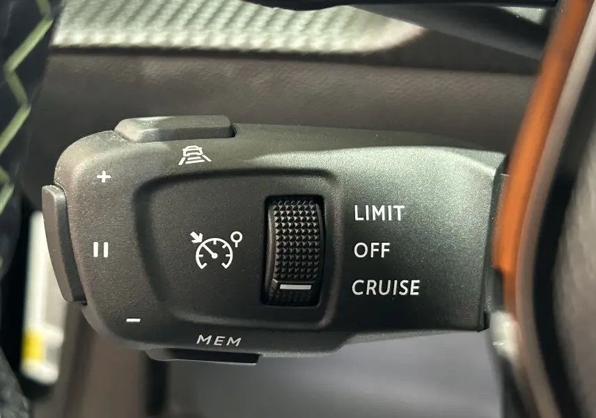 Gros plan sur la commande de régulateur de vitesse au volant d’un Peugeot 2008 noir, avec options Limit, Off, Cruise.