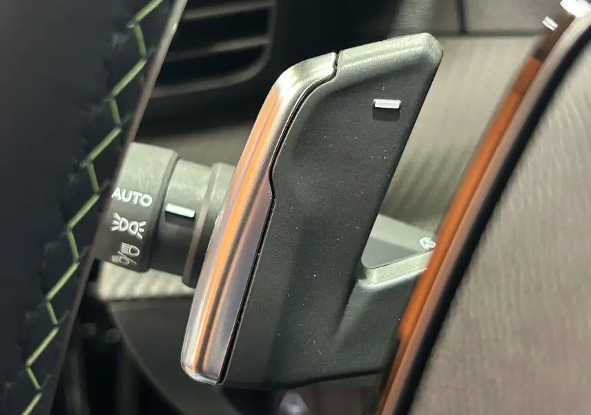 Gros plan sur la palette de changement de vitesse droite noire et argentée dans l’habitacle du Peugeot 2008 Hybrid 136 e-DCS6 GT.