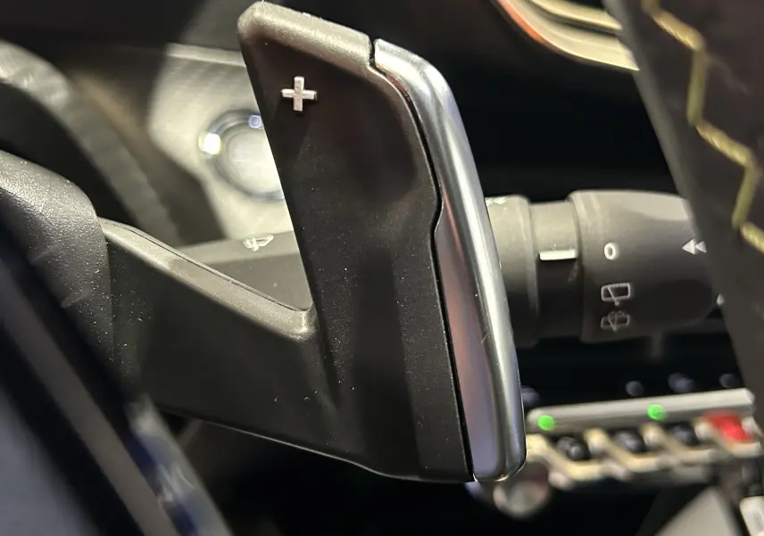 Gros plan sur la palette de changement de vitesse droite noire et argentée du Peugeot 2008 Hybrid 136 e-DCS6 GT, intérieur moderne.