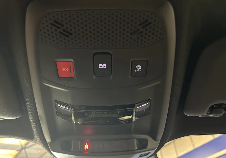 Vue en contre-plongée du plafonnier noir avec boutons SOS, appel et éclairage intérieur du Peugeot 2008 Hybrid 136 e-DCS6 GT.